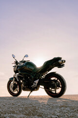 Fototapeta na wymiar amazing sport black motorcycle parked with pink sunset sky