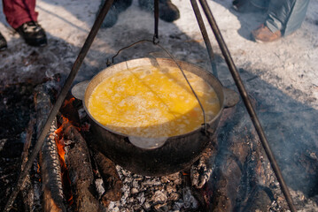 Cooking field porridge over the fire with a moss in the forest.
Large cauldron of porridge. Hiking...