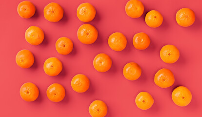 Fruit pattern of fresh orange tangerine or mandarin on living coral background. Flat lay, top view. Pop art design, creative summer concept. Citrus in minimal style.