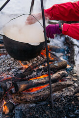 Cooking field porridge over the fire with a moss in the forest.
Large cauldron of porridge. Hiking tourist food.