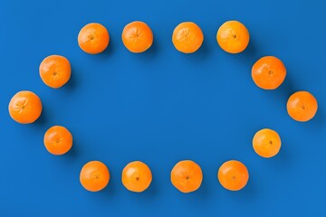 Fruit pattern of fresh orange tangerine or mandarin on blue background. Flat lay, top view. Pop art design, creative summer concept. Citrus in minimal style.
