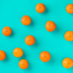 Fruit pattern of fresh mandarin on blue background. Flat lay, top view. Pop art design, creative summer concept. Citrus in minimal style.