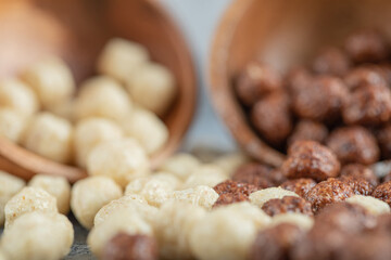 Wooden bowls with sweet corn balls on a gray background