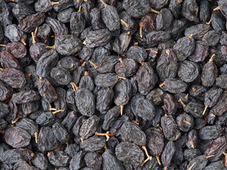 Black dried grapes on a white background