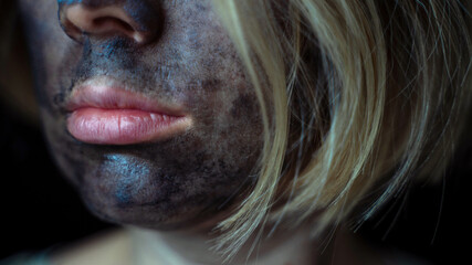 women's lips and a cleansing charcoal mask on her face