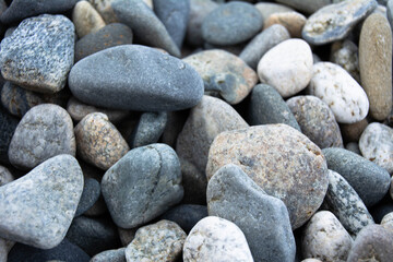 Fototapeta na wymiar Multicolored pebble stones on the beach close-up. Horizontal photo