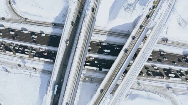 Aerial overhead rising shot of a busy motorway interchange and traffic jam in winter