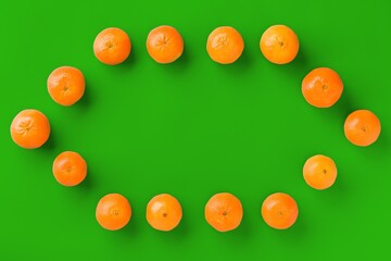 Fruit pattern of fresh orange tangerine or mandarin on green background. Flat lay, top view. Pop art design, creative summer concept. Citrus in minimal style.