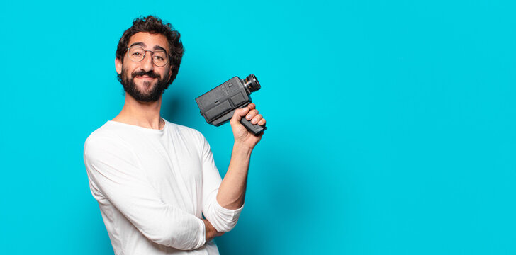 young crazy bearded man with a super 8 camera