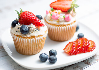 Closeup Cupcakes  with blueberry and strawberry on white plate and background 