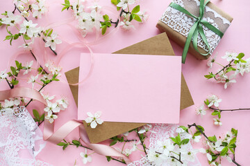 greeting card mockup made of spring flowers, gift box, envelope and white blank for text 