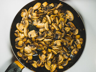 Lots of fried chopped mushrooms in a pan