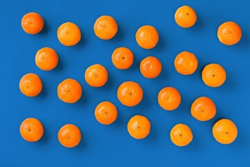 Fruit pattern of fresh orange tangerine or mandarin on blue background. Flat lay, top view. Pop art design, creative summer concept. Citrus in minimal style.