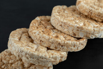 Pile of crispy rice cakes on black background