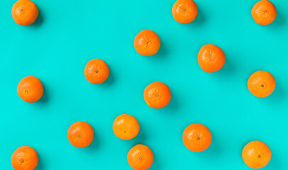 Fruit pattern of fresh mandarin on blue background. Flat lay, top view. Pop art design, creative summer concept. Citrus in minimal style.