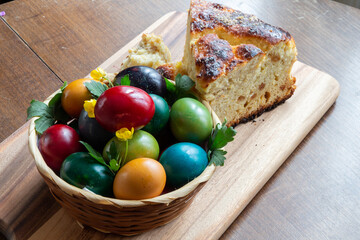 Easter eggs and Easter bun with flowers - wood background