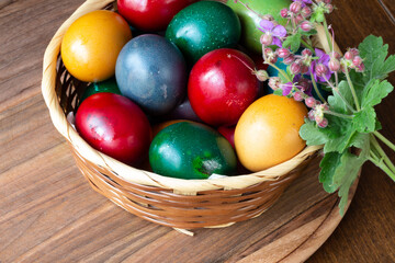 Obraz na płótnie Canvas Easter eggs and Easter bun with flowers - wood background