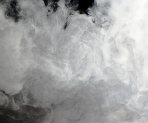 Abstract background of chaotically mixing clouds of white smoke against a background of darkness