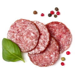 Slices of salami isolated on white background closeup. Sausage and basil leaves top view.