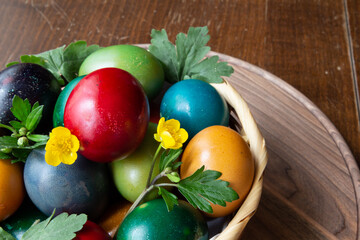 Easter eggs and Easter bun with flowers - wood background