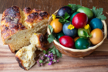 Easter eggs and Easter bun with flowers - wood background