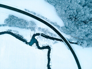 aerial view of a river and a road in a white winter landscape