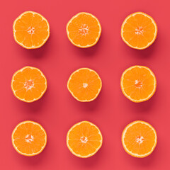 Fruit pattern of fresh orange tangerine or mandarin on living coral background. Flat lay, top view. Pop art design, creative summer concept. Citrus in minimal style.