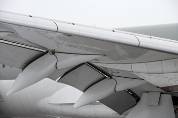 Wing details closeup. Modern passenger airplane parked at the winter airport apron before departure. The view on the wing, the chassis rack gear.