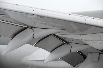 Wing details closeup. Modern passenger airplane parked at the winter airport apron before departure. The view on the wing, the chassis rack gear.