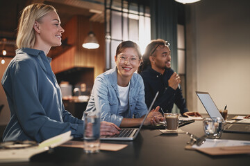 Smiling Asian businesswoman working with colleagues in an office