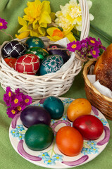 Fototapeta na wymiar Easter eggs and Easter bun with flowers - green background