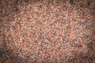 Dark red granite background, structured background with vignetting, darkening around the edges of the photo. Natural stone texture.