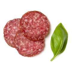 Slices of salami isolated on white background closeup. Sausage and basil leaves top view.