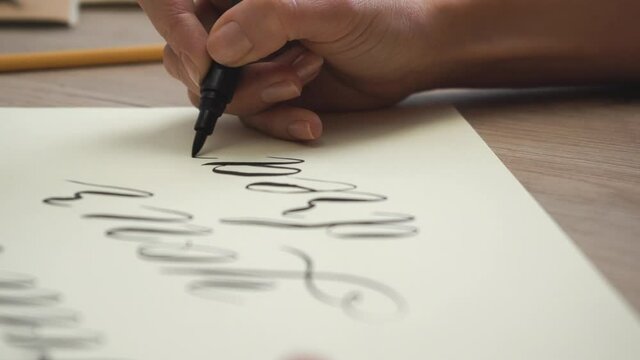 Female Hand is Writing Follow your Dreams in Calligraphic Form / Close Up