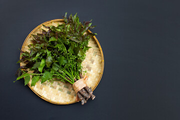 Neem leaves and flowers on dark background.