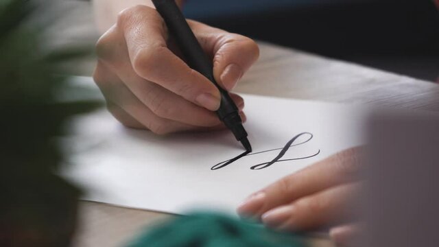 Female Hand is Writing Hello in Calligraphic Form Close Up