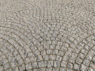 Granite paving stones on the sidewalk, textured paving background.