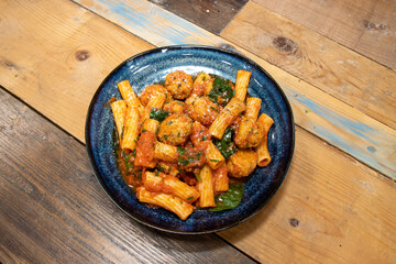 A delicious plate of pasta and meatballs on a wooden background