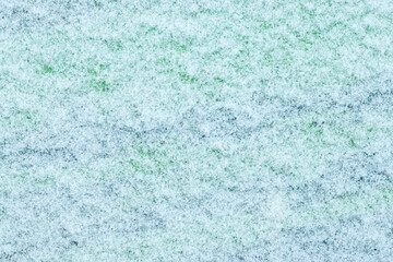 Snow on a green and blue surface background for an inscription, design or banner.