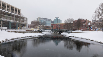 Kalamazoo, Michigan, USA - February 5 2021: Downtown Kalamazoo in snow. view from Arcadia Creek playground.