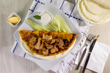 Comida típica de Venezuela servido en plato para restaurante, cachapas con relleno de queso jamón, cochino frito