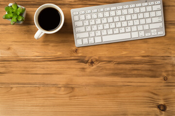 Overhead above close up view photo picture of computer keyboard cup of espresso and green succulent...