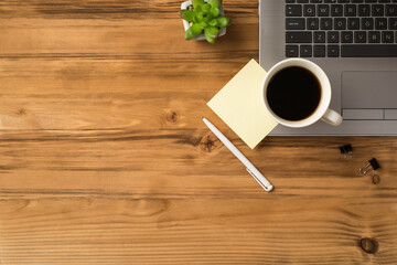 Overhead above close up flat lay view photo of laptop notebook with cup of coffee notice paper pen isolated brown light table with blank empty space