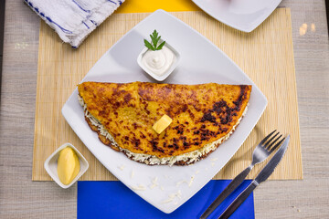Comida típica de Venezuela servido en plato para restaurante, cachapas con relleno de queso...