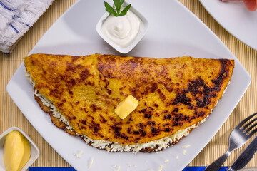 Comida típica de Venezuela servido en plato para restaurante, cachapas con relleno de queso jamón, cochino frito