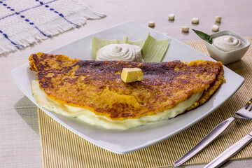 Comida típica de Venezuela servido en plato para restaurante, cachapas con relleno de queso jamón, cochino frito