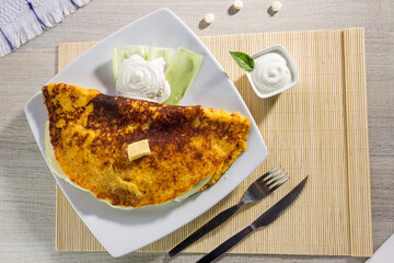 Comida típica de Venezuela servido en plato para restaurante, cachapas con relleno de queso jamón, cochino frito