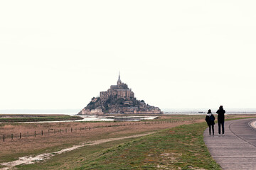 Couple walking along a path to Mount Saint Michel