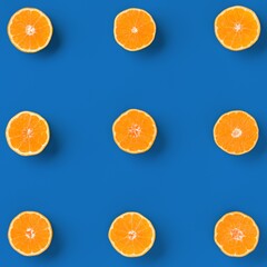 Fruit pattern of fresh orange tangerine or mandarin on blue background. Flat lay, top view. Pop art design, creative summer concept. Citrus in minimal style.