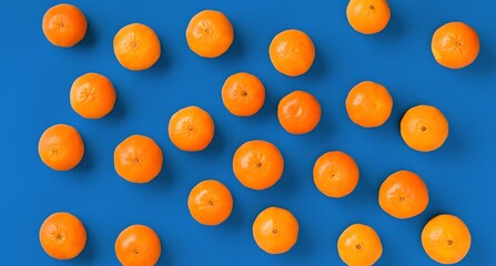 Fruit pattern of fresh orange tangerine or mandarin over blue background. Flat lay, top view. Pop art design, creative summer concept. Citrus in minimal style.